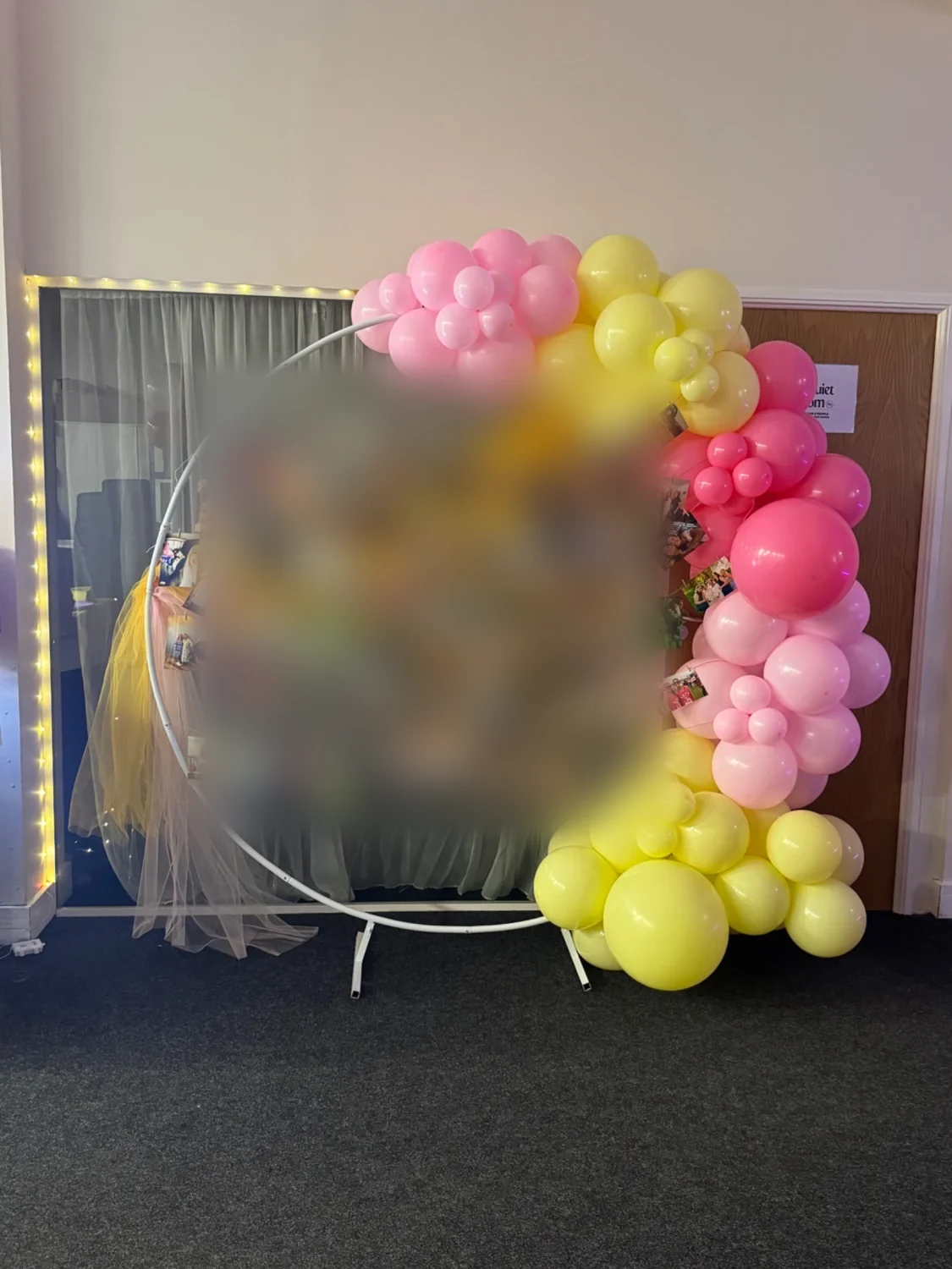 Pink and yellow balloon display with photo memories